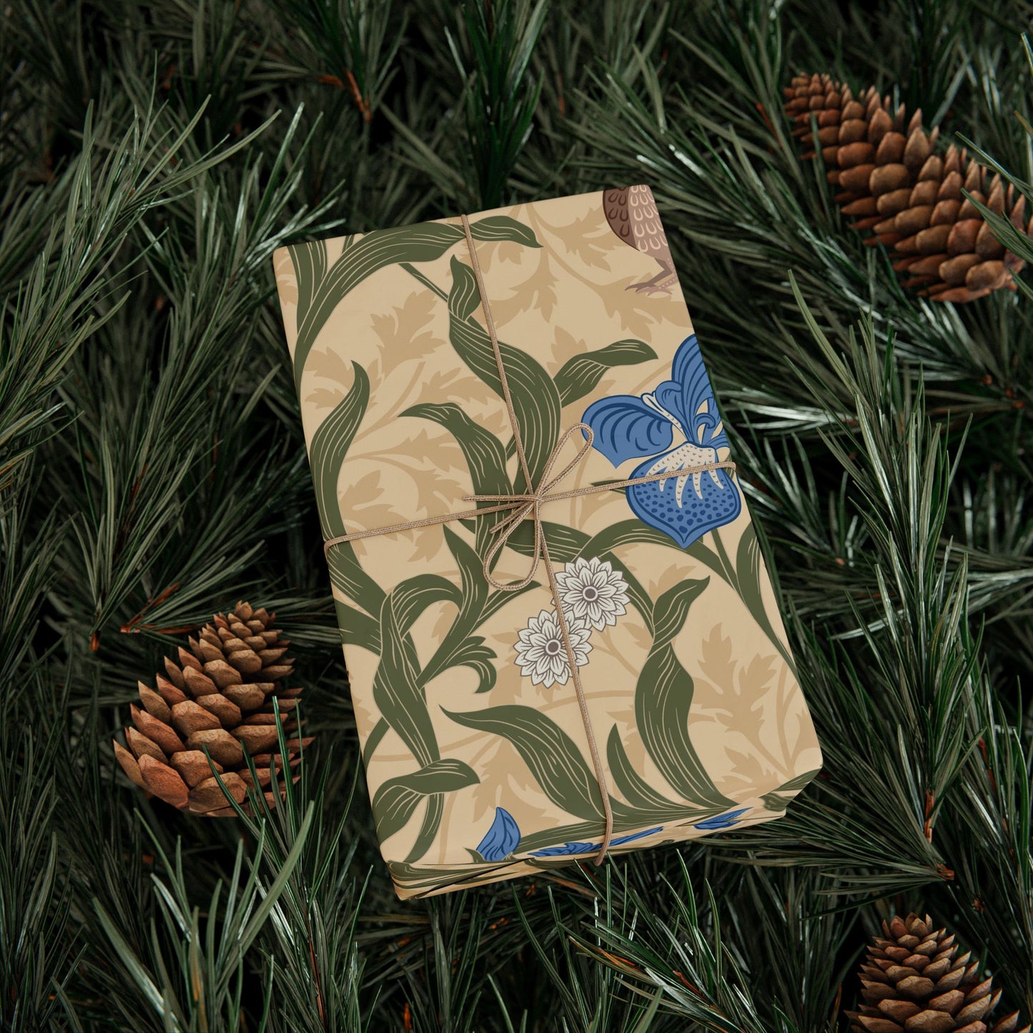 Gifts wrapped in decorative wrapping paper with William Morris & Co floral patterns, placed on a table alongside a roll of paper, scissors, and tags.