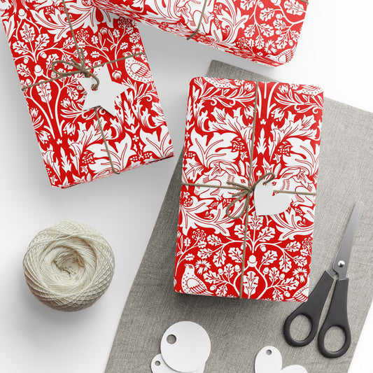 Gifts wrapped in red and white patterned paper with scissors and yarn on a gray surface.