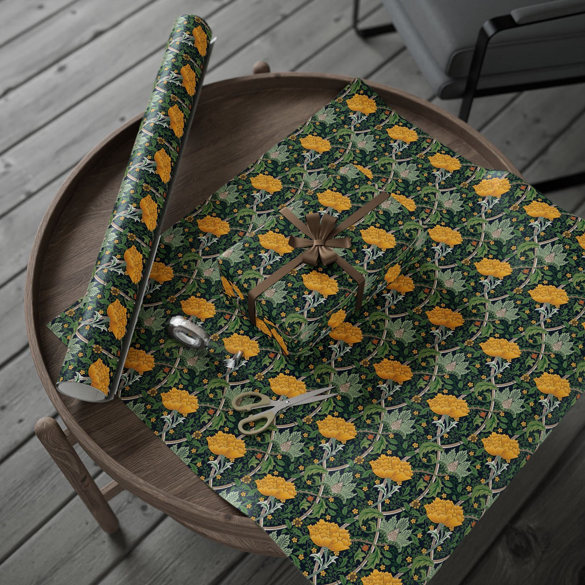 Green and yellow floral-patterned wrapping paper on a wooden table with scissors.