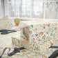 Gift box wrapped in floral patterned paper with scissors on a matching surface.