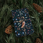 Gift wrapped in dark blue paper with owl design on pine branches