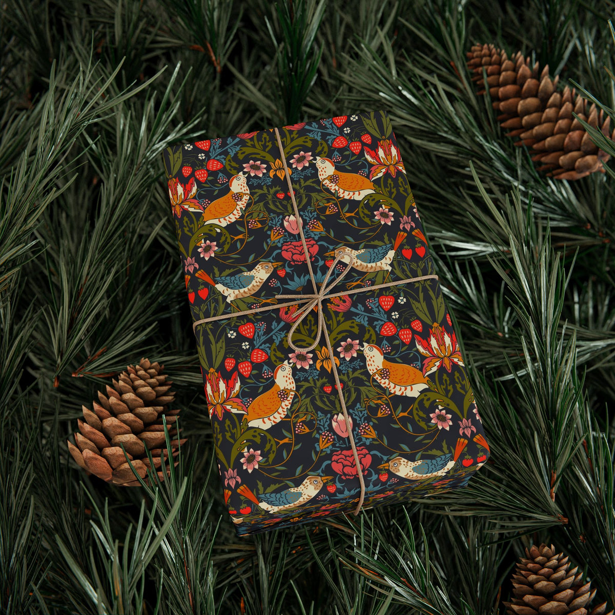 Gift wrapped in colorful paper with bird pattern on green leaves and pine cones.