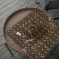 Table with a floral patterned cloth and scissors on a wooden deck.