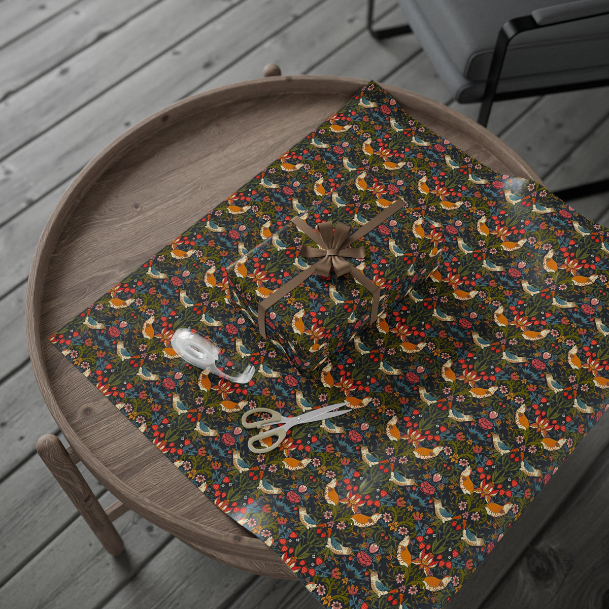 Table with a floral patterned cloth and scissors on a wooden deck.