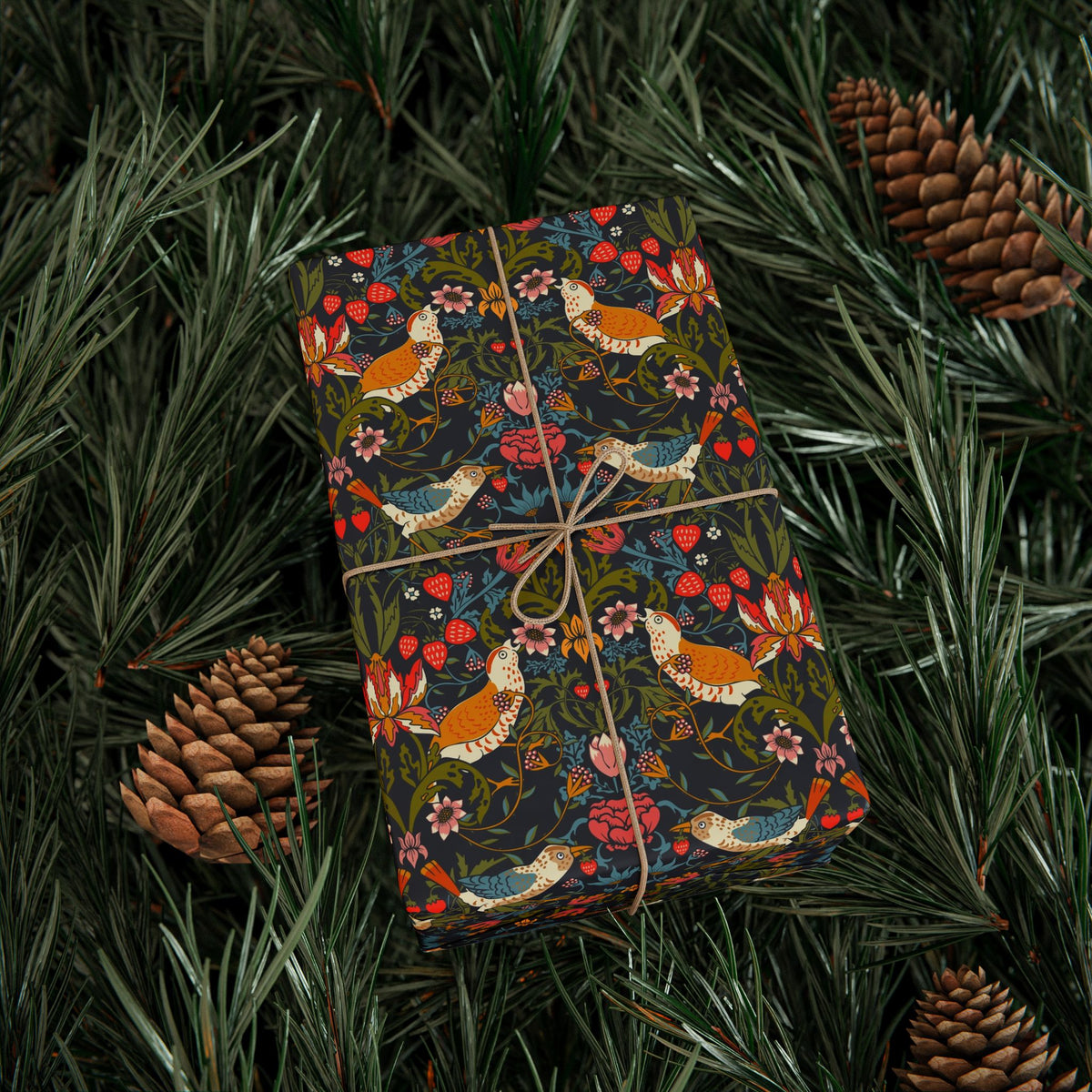 Gift wrapped in colorful paper with bird pattern on green leaves and pine cones.