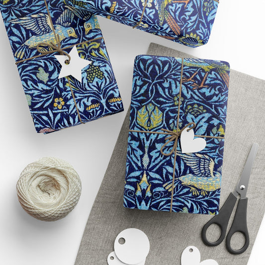 Gift-wrapped items with blue floral pattern, scissors, and yarn on a white surface