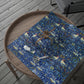 Blue patterned tablecloth with birds and flowers on a wooden tray