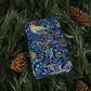 Blue patterned book tied with string on green foliage with pine cones