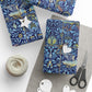 Gift-wrapped items with blue floral pattern, scissors, and yarn on a white surface