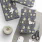 Gift boxes wrapped in purple floral paper with decorative elements on a white surface.