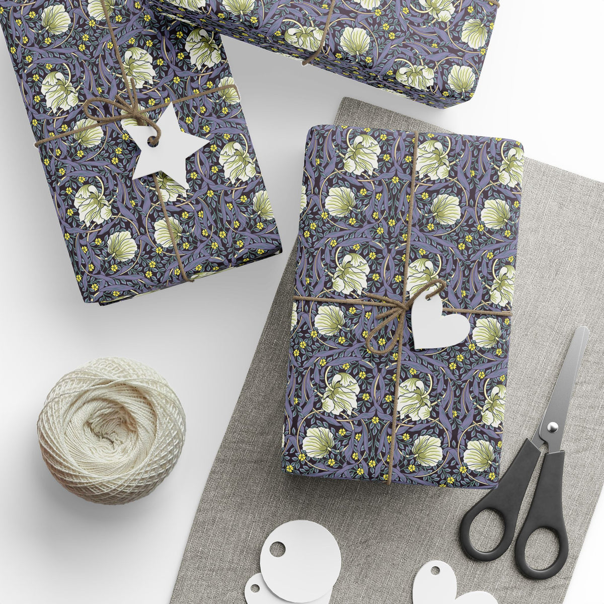 Gift boxes wrapped in purple floral paper with decorative elements on a white surface.