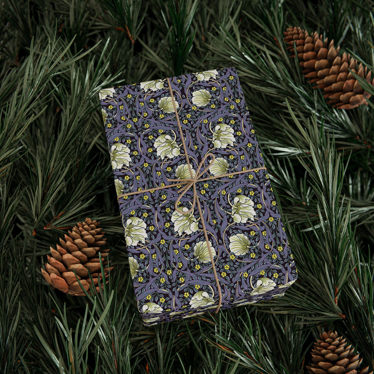 Decorative box with floral pattern on a bed of pine needles and cones
