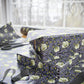 Floral-patterned fabric on a table with scissors and a box.