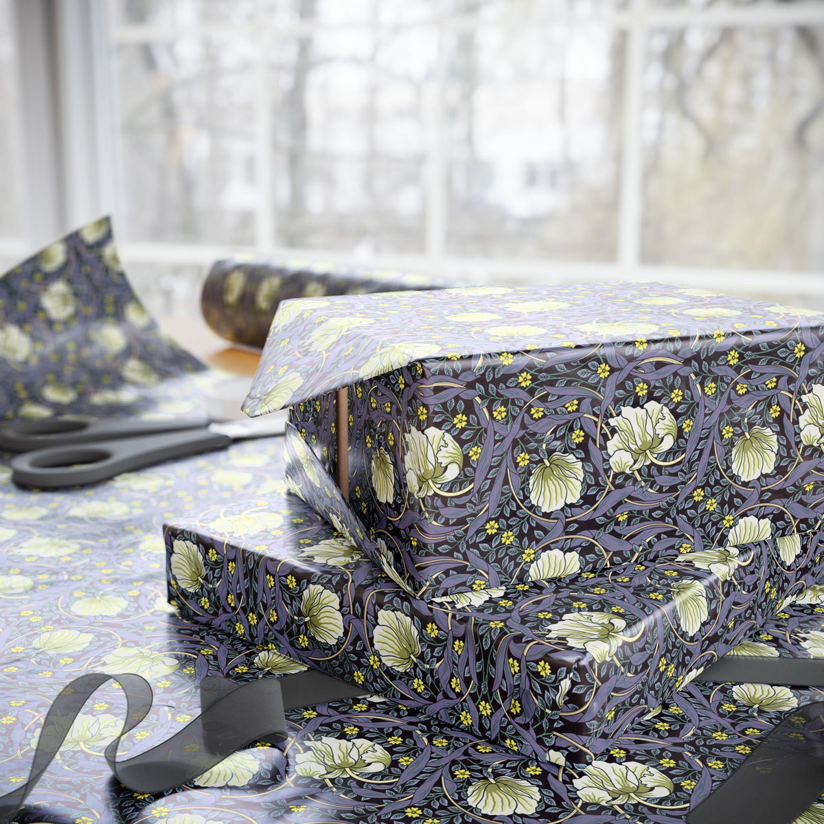 Floral-patterned fabric on a table with scissors and a box.