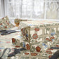 Gift box wrapped in floral-patterned paper with scissors on a matching surface.