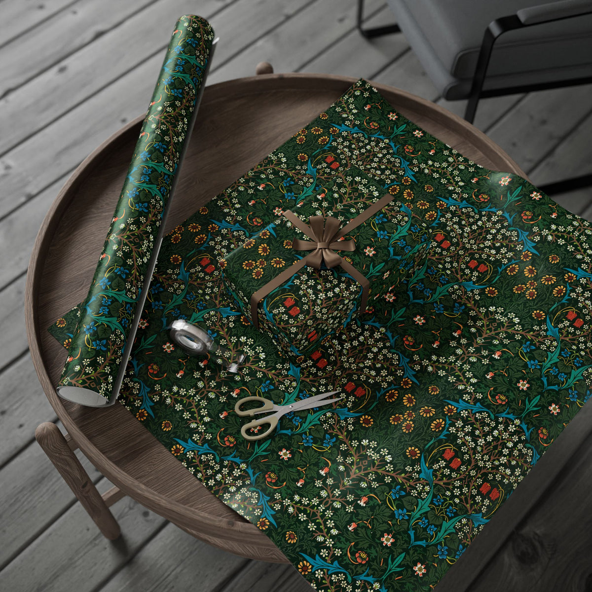 Roll of green floral-patterned paper with scissors on a wooden surface