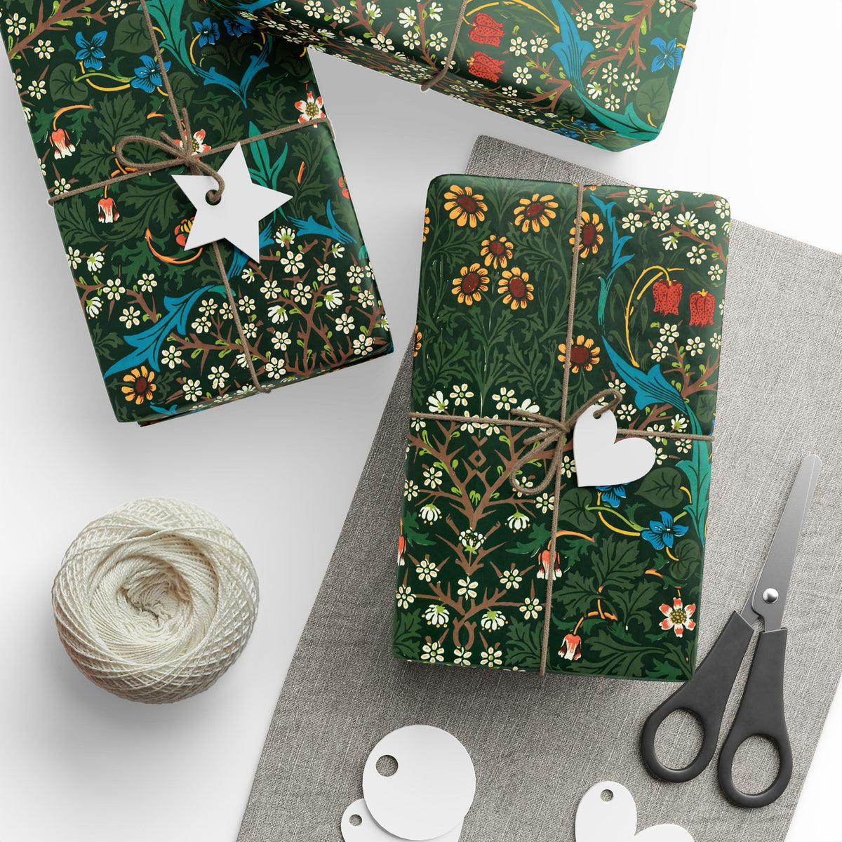 Gift boxes with floral patterns, string, and scissors on a white surface