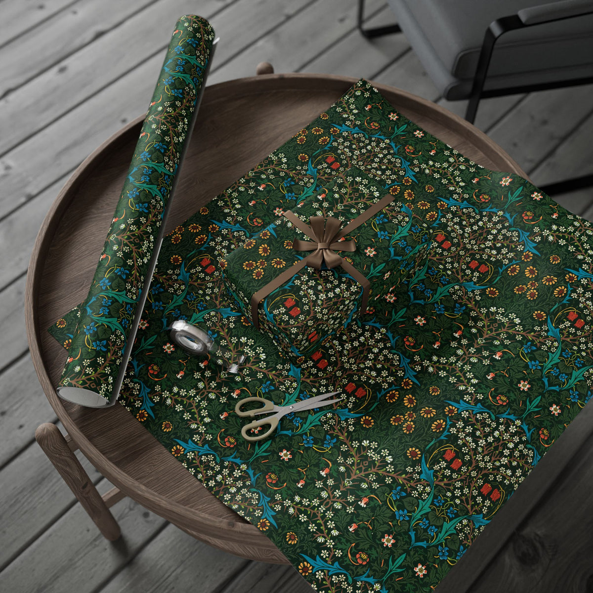 Floral-patterned wrapping paper on a wooden table with scissors.