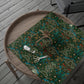 Floral-patterned fabric on a wooden tray with scissors and a spool of thread.