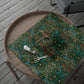 Floral-patterned green fabric on a wooden tray with scissors and thread.