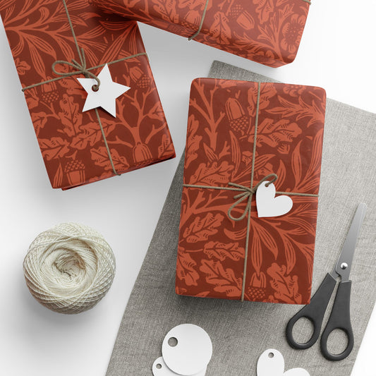 Gift boxes with red floral patterns, decorative tags, scissors, and yarn on a white surface.