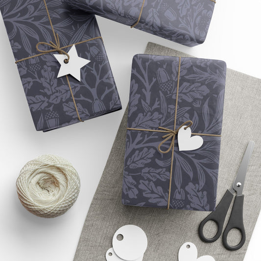 Gift boxes wrapped in dark blue patterned paper with decorative tags and scissors on a light surface.