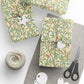 Gift boxes wrapped in decorative paper with birds and branches, accompanied by scissors and yarn.