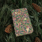 Pink notebook with nature-themed design on green leaves and pine cones