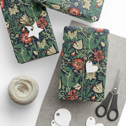 Floral-patterned gift wrap with decorative tags and scissors on a white surface