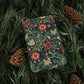 Floral-patterned gift box tied with string on a bed of pine needles and pine cones.