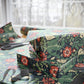 Gift boxes wrapped in floral patterned paper with scissors on a matching tablecloth.