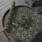 Floral-patterned fabric on a wooden tray with scissors on a wooden deck.