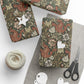 Gift boxes wrapped in floral paper with decorative tags and scissors on a white surface