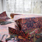Decorative boxes with floral pattern on a table with scissors and ribbon.