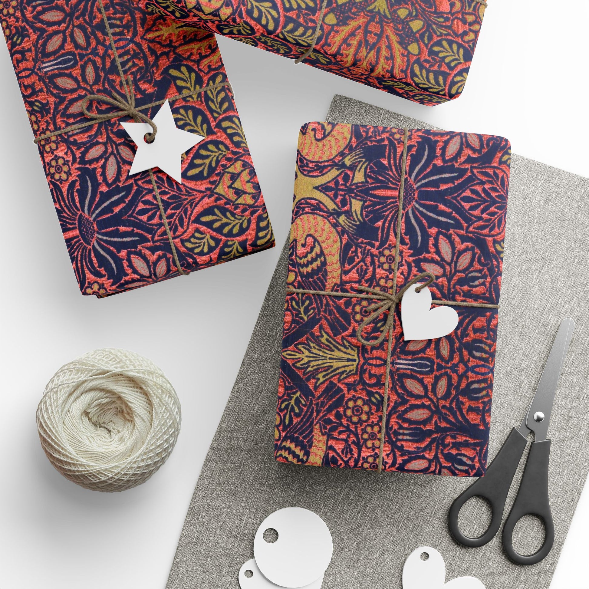 Decorative fabric roll with floral pattern, scissors, and yarn on a white background