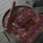 Decorative floral-patterned paper with scissors on a wooden tray outdoors.