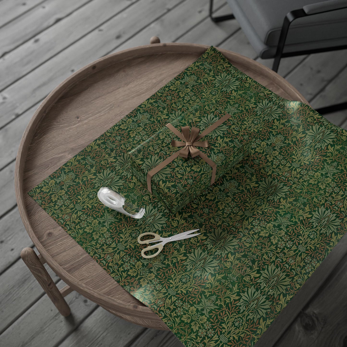 Green patterned fabric with a bow and scissors on a wooden surface
