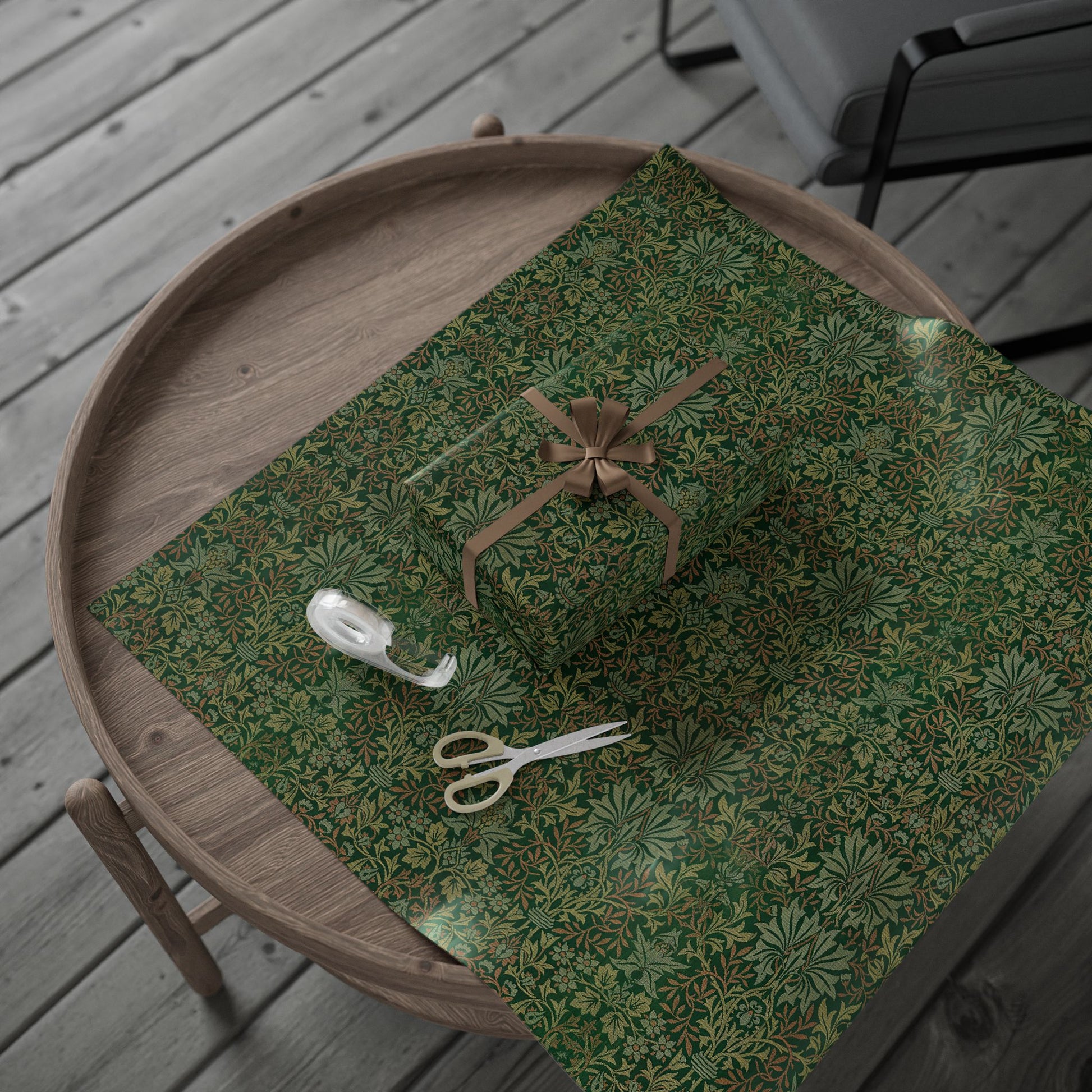Green patterned fabric with a bow and scissors on a wooden surface