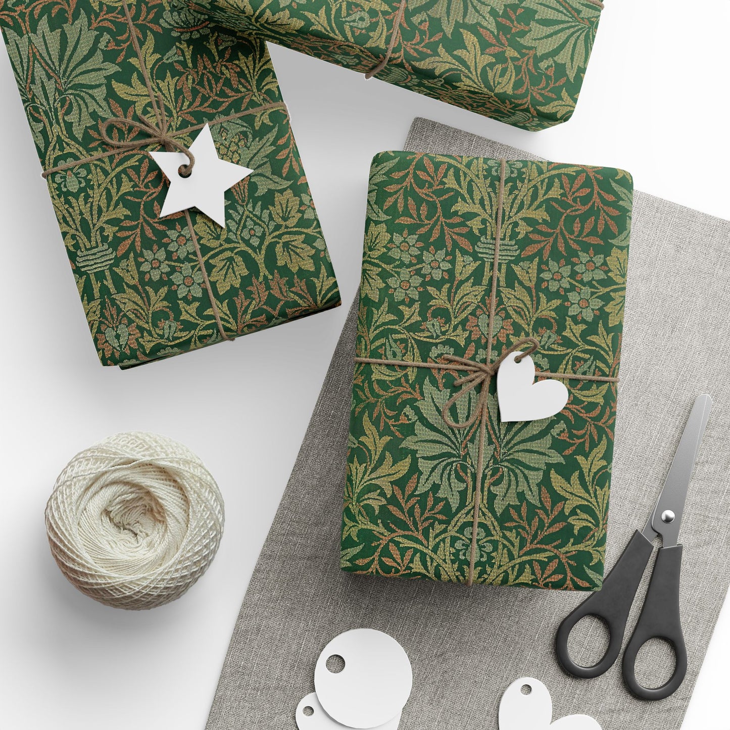 Green patterned gift wrap with decorative tags and scissors on a white surface