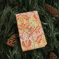 Gift wrapped in orange floral paper with twine on green foliage