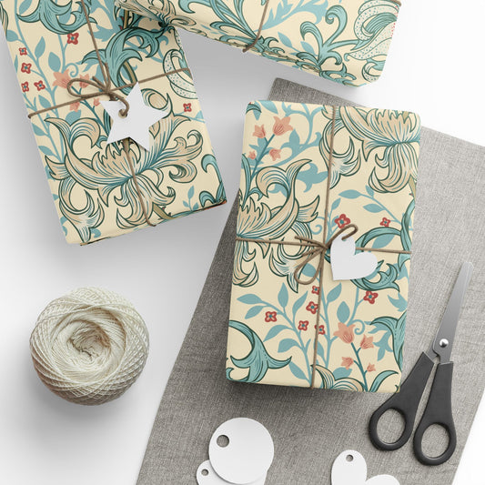 Gift boxes wrapped in decorative paper with a floral pattern, scissors, and yarn on a white surface.