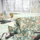Gift box wrapped in floral patterned paper with scissors on a table.