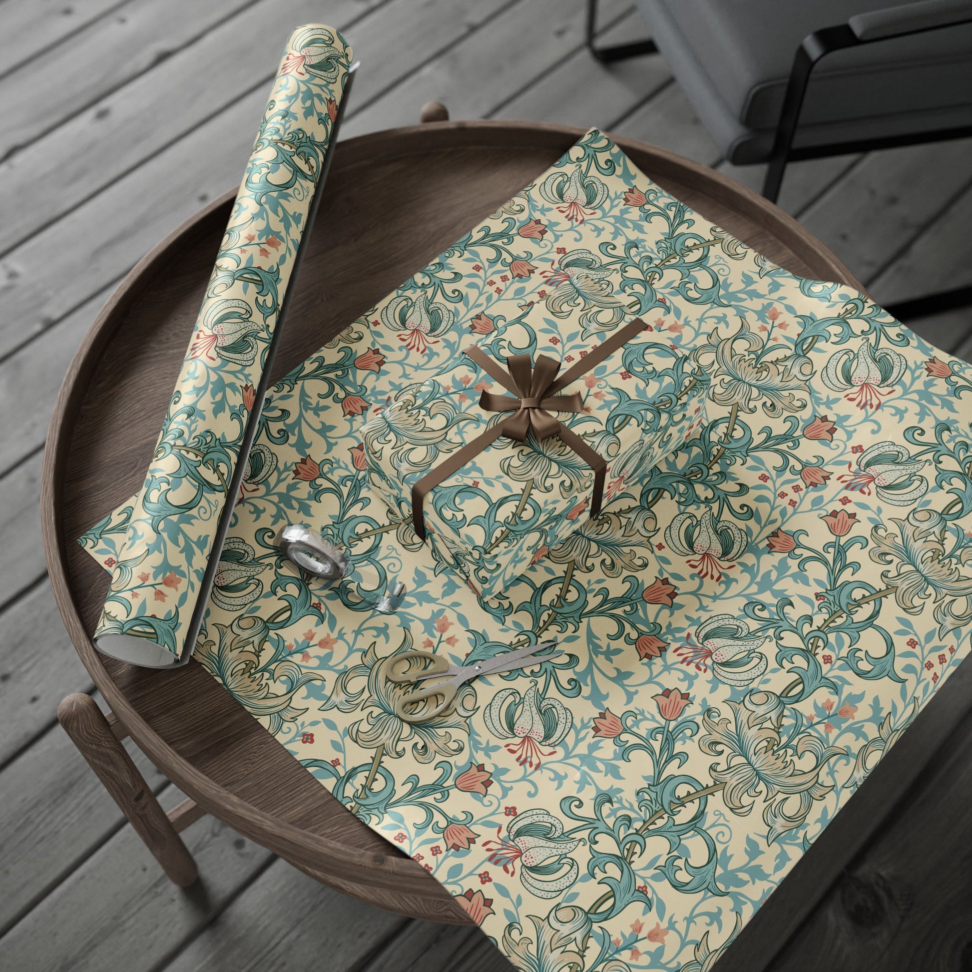 Floral-patterned gift wrap with a brown ribbon on a wooden surface