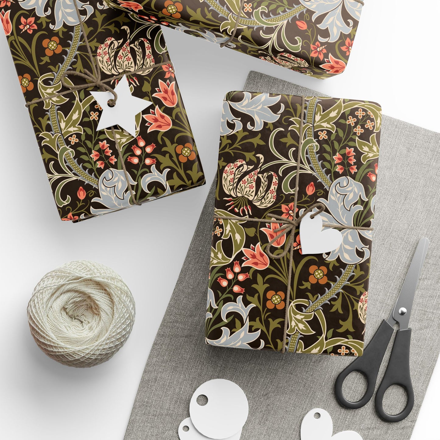 Decorative notebooks with floral patterns on a white surface with scissors and yarn.