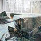 Gift box with floral pattern on a table with scissors and wrapping paper in the background.