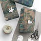 Gift boxes wrapped in nature-themed paper with decorative tags and scissors on a white surface.