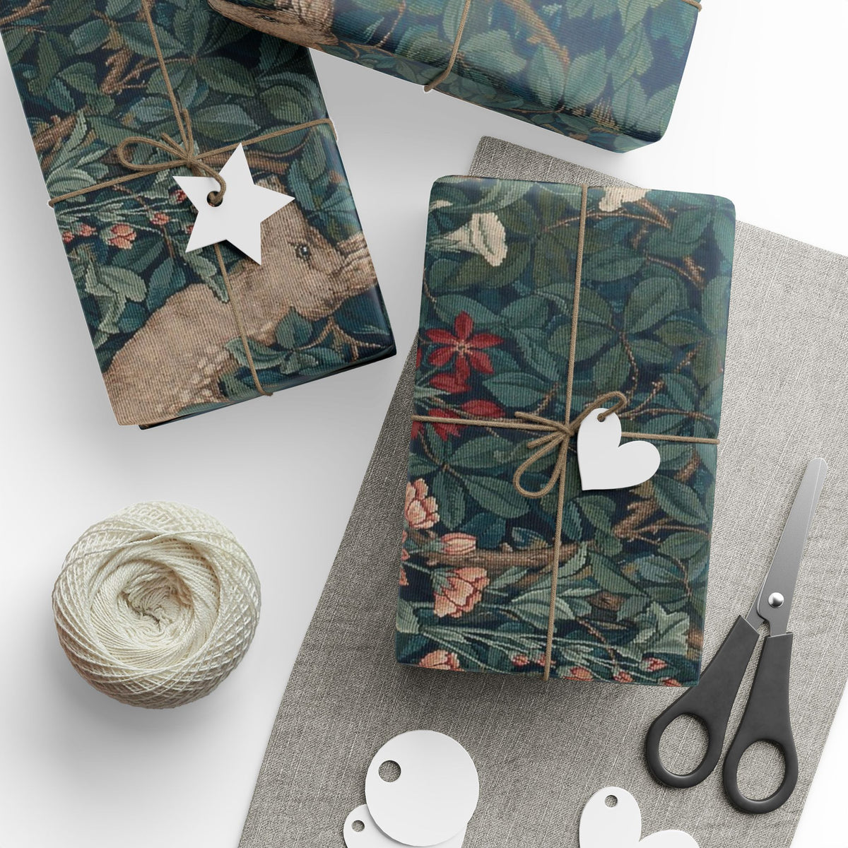 Gift boxes with floral patterns, decorative tags, and scissors on a white surface