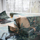 Gift box wrapped in floral-patterned paper with scissors on a table.