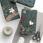 Gift boxes wrapped in floral paper with decorative tags and scissors on a white surface