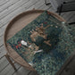 Wooden tray with a green floral-patterned wrapping paper, sewing items, and a chair in the background.